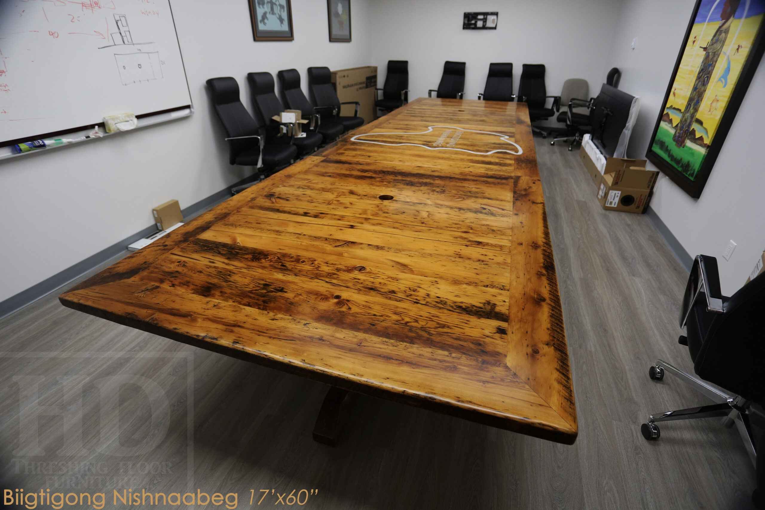 Project details: 17â€™ Reclaimed Ontario Barnwood Table we made for a Marathon, Ontario community centre â€“ Hand-Hewn Beam Pedestals Base - Old Growth Hemlock Threshing Floor Construction â€“ Original edges & distressing maintained â€“ Bread Edge Ends â€“ Custom Steel Graphic Embedded - Premium epoxy + satin polyurethane finish â€“ Top Built in 3 parts / Onsite Final Assembly - www.table.ca