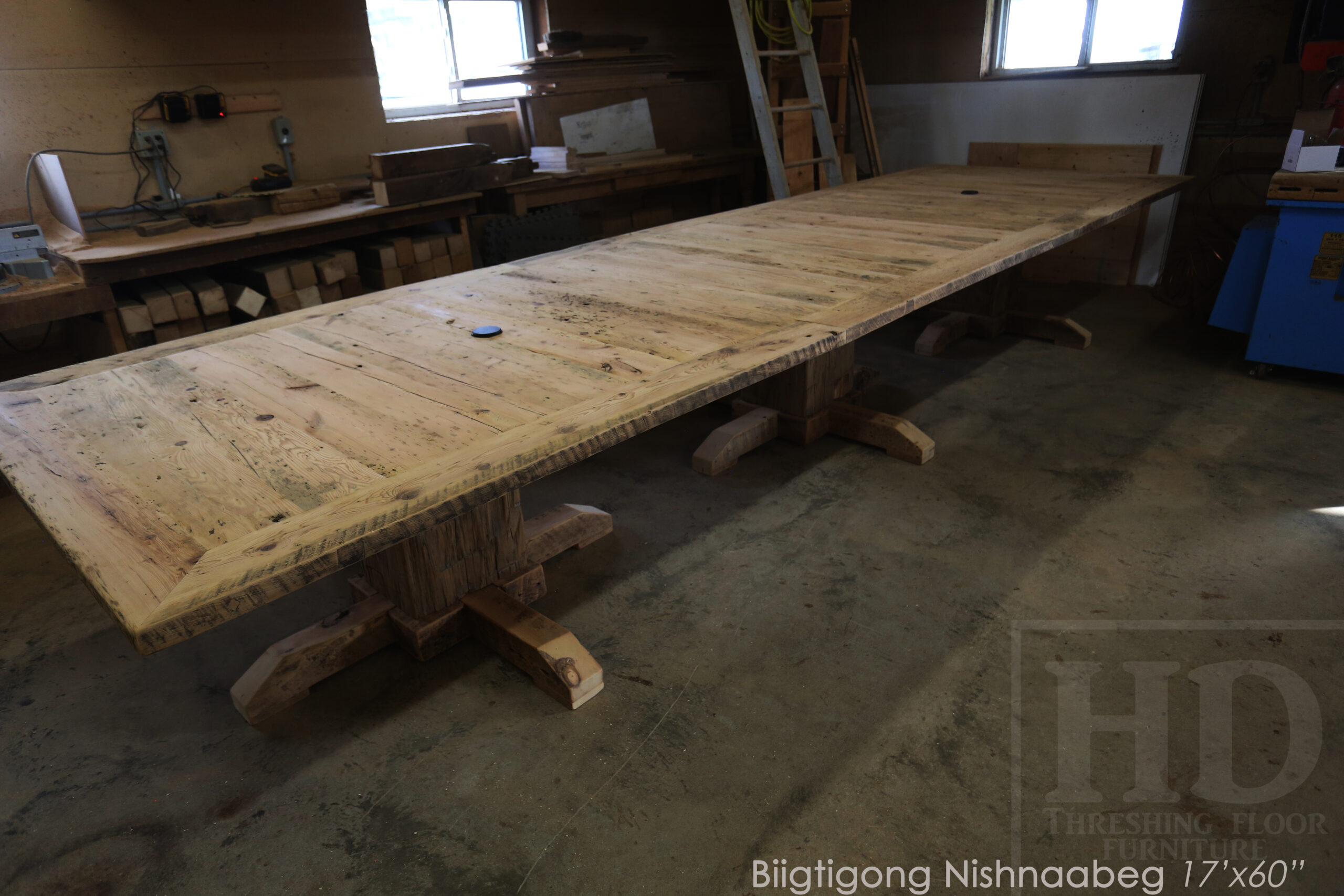 Project details: 17’ Reclaimed Ontario Barnwood Table we made for a Marathon, Ontario community centre – Hand-Hewn Beam Pedestals Base - Old Growth Hemlock Threshing Floor Construction – Original edges & distressing maintained – Bread Edge Ends – Custom Steel Graphic Embedded - Premium epoxy + satin polyurethane finish – Top Built in 3 parts / Onsite Final Assembly - www.table.ca