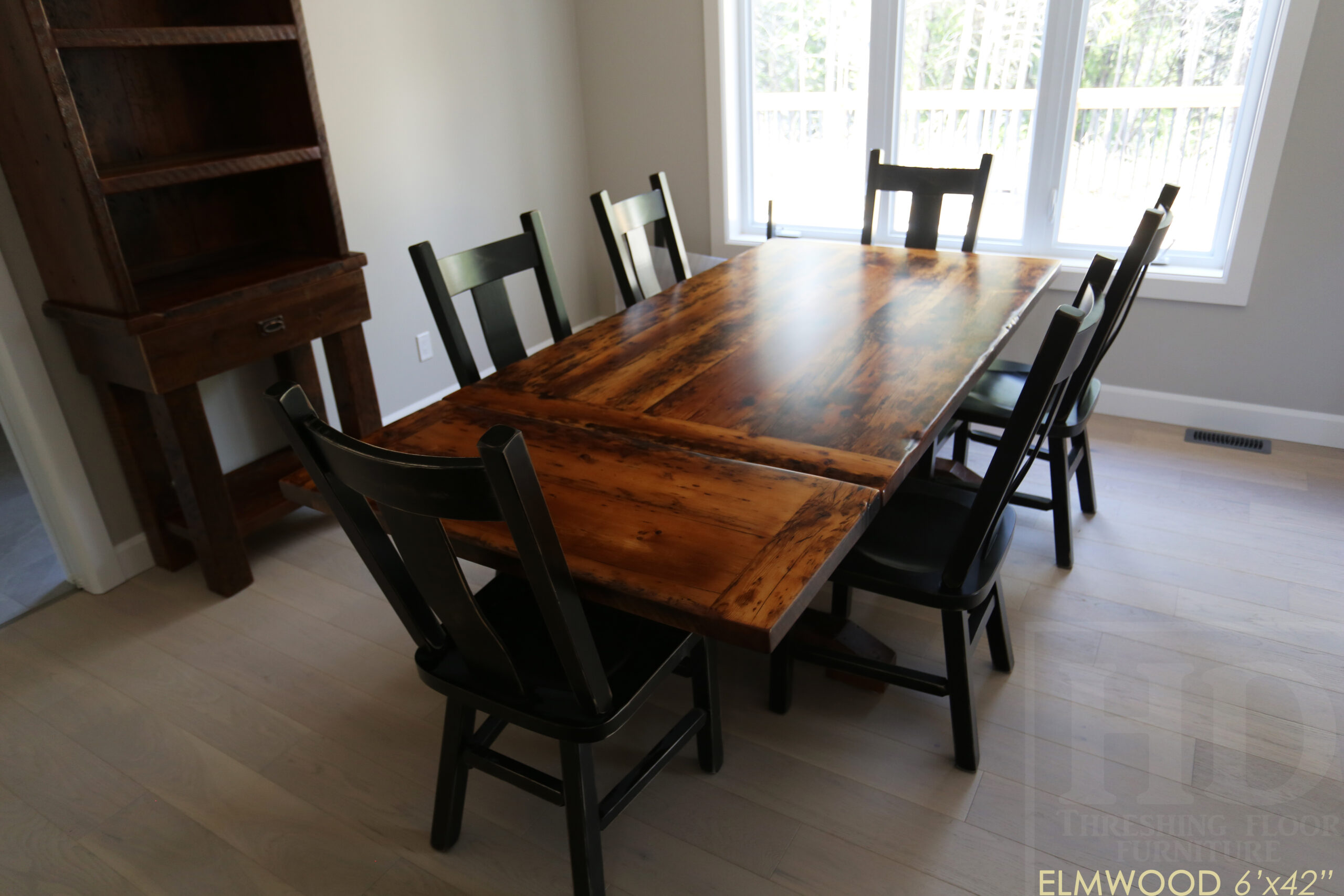 6’ Reclaimed Ontario Barnwood Table we made for an Elmwood, Ontario home – 42” wide – Trestle Base - Old Growth Hemlock Threshing Floor Construction - Original edges & distressing maintained – Bread Edge Board Ends – Premium epoxy + satin polyurethane finish – Two 18” Leaf Extensions – 6 Plank Back Chairs / Wormy Maple / Black with Sandthroughs / Polyurethane Clearcoat Finish - www.table.ca