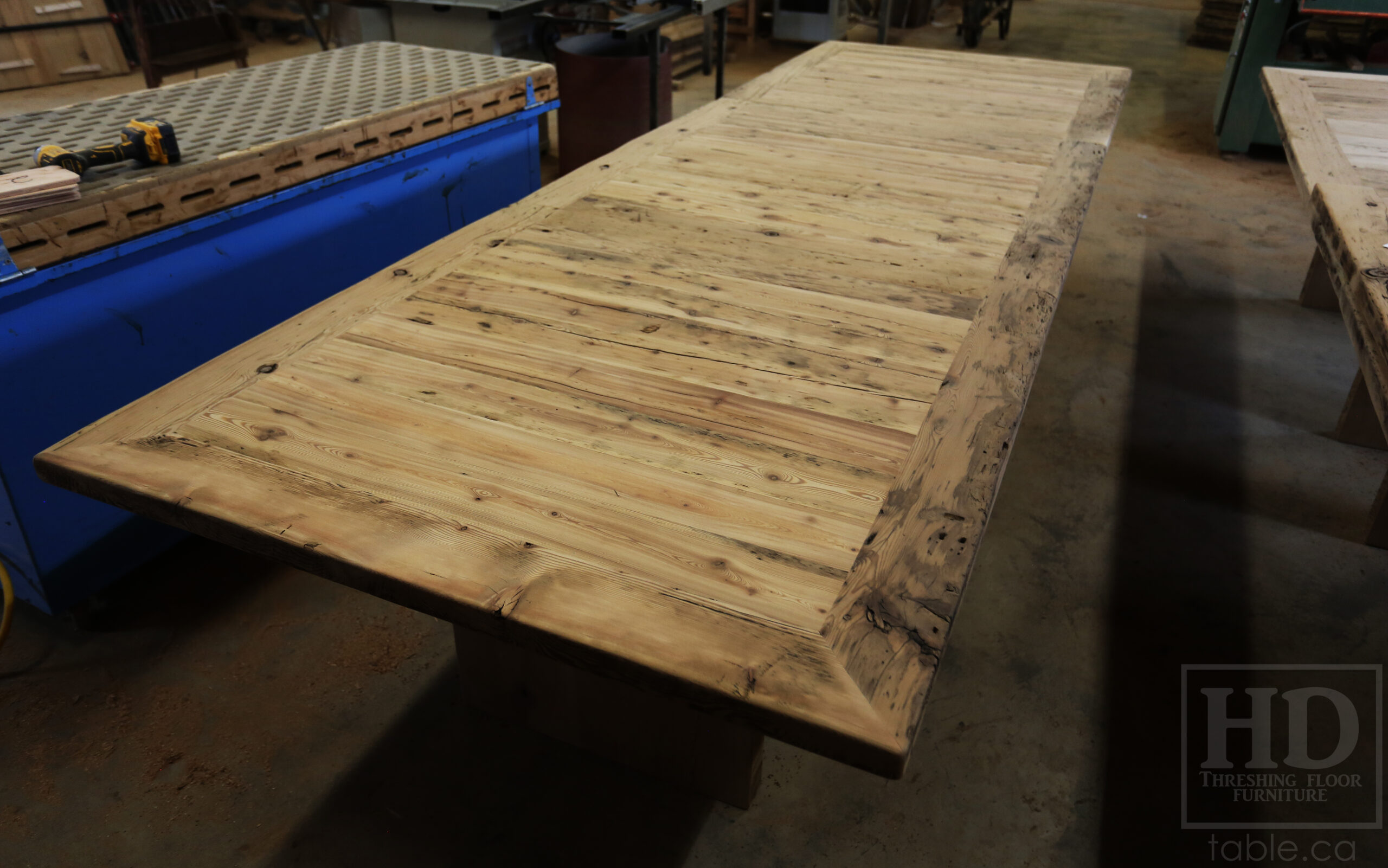 Project Summary: [TWO] 12â€™ Reclaimed Barnwood Tables we made for a Kitchener, Ontario organization â€“ 48â€ wide â€“ Plank 3â€ Joist Material Bases â€“ 2 Underside rails to hide electronics - Old Growth Hemlock Threshing Floor  Construction - Original edges & distressing maintained â€“ Bread Edge Boards â€“ Premium epoxy + satin polyurethane finish â€“ Grommet holes cut -  www.table.ca