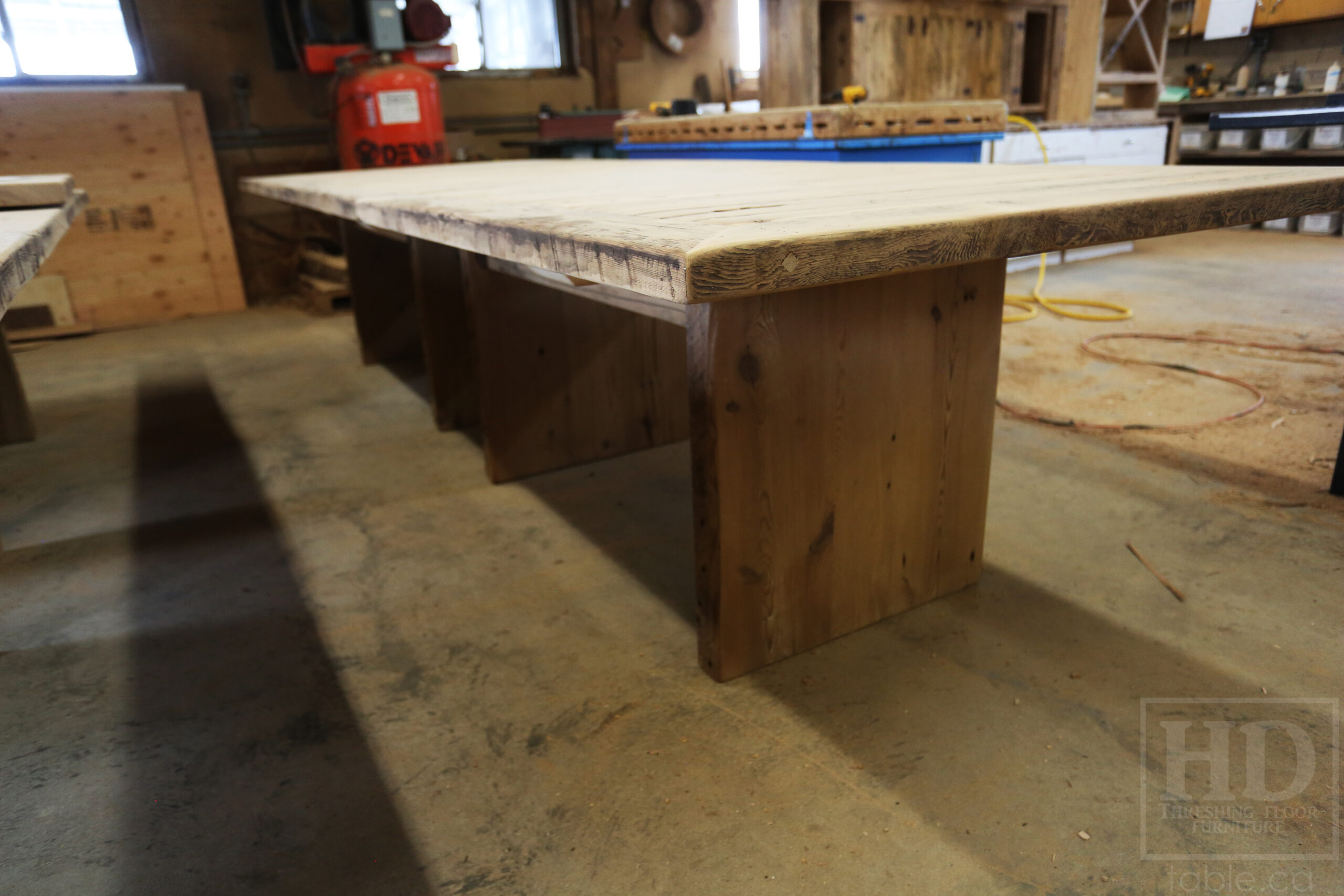 Project Summary: [TWO] 12â€™ Reclaimed Barnwood Tables we made for a Kitchener, Ontario organization â€“ 48â€ wide â€“ Plank 3â€ Joist Material Bases â€“ 2 Underside rails to hide electronics - Old Growth Hemlock Threshing Floor  Construction - Original edges & distressing maintained â€“ Bread Edge Boards â€“ Premium epoxy + satin polyurethane finish â€“ Grommet holes cut -  www.table.ca