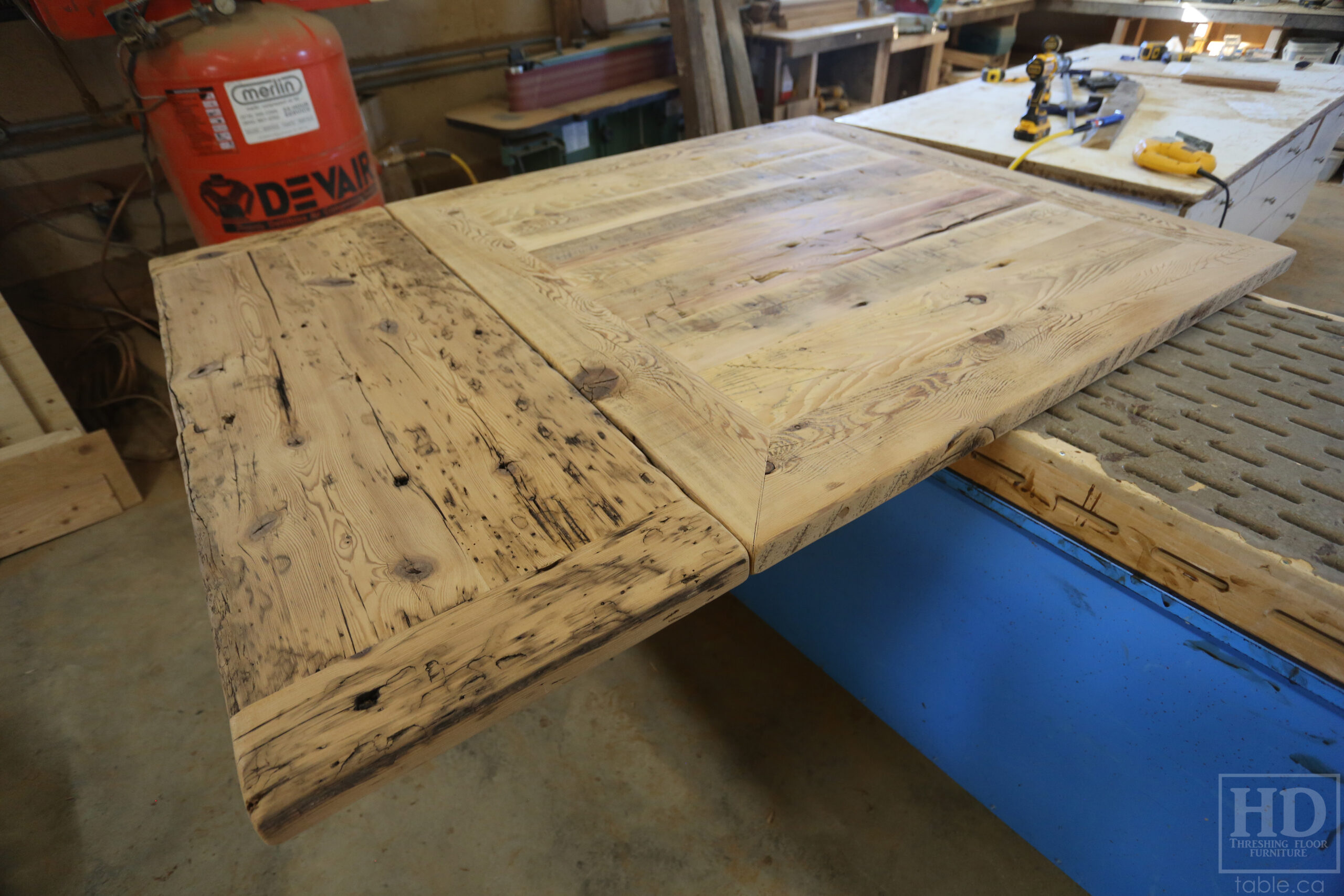 50" x 50" Ontario Barnwood Table we made for a Toronto Company - X Shaped Metal Base - Mitred Corners - Reclaimed Old Growth Hemlock Threshing Floor Construction - Original edges & distressing maintained - Premium epoxy + satin polyurethane finish  - One 18" Leaf Extension - www.table.ca